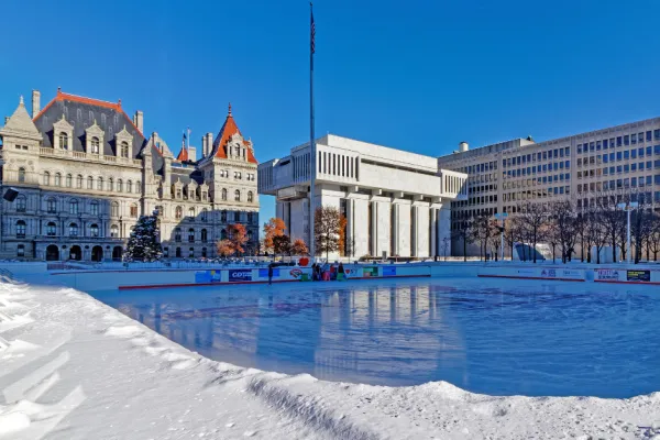New York State Capitol building in the winter behind Empire State Plaza ice rink