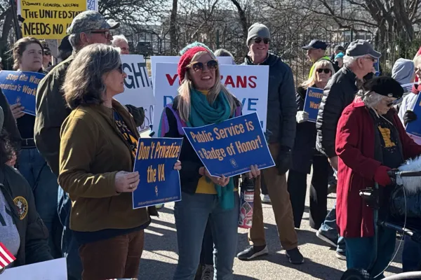 Federal workers holding signs that say, "Public Service is a Badge of Honor."