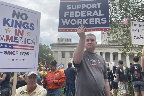Photo of a protest, with a man holding a sign saying "Support Federal Workers"