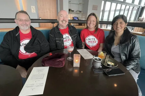 A group of four people all wearing red shirts that say "Unite Here"